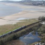 The train seen from above with Morecambe Bay and Grange in the background (Image: Network Rail)